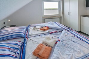 Une chambre à coucher avec un lit, des oreillers et une fenêtre.