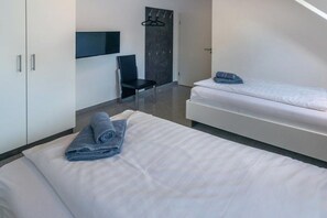 Ein Hotelzimmer mit Bett, Stuhl, Kleiderschrank und Garderobe.