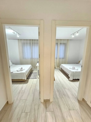 A hotel room with two beds, a small table, and a mirror. - Luminous Escape to La Marsa (La Marsa)