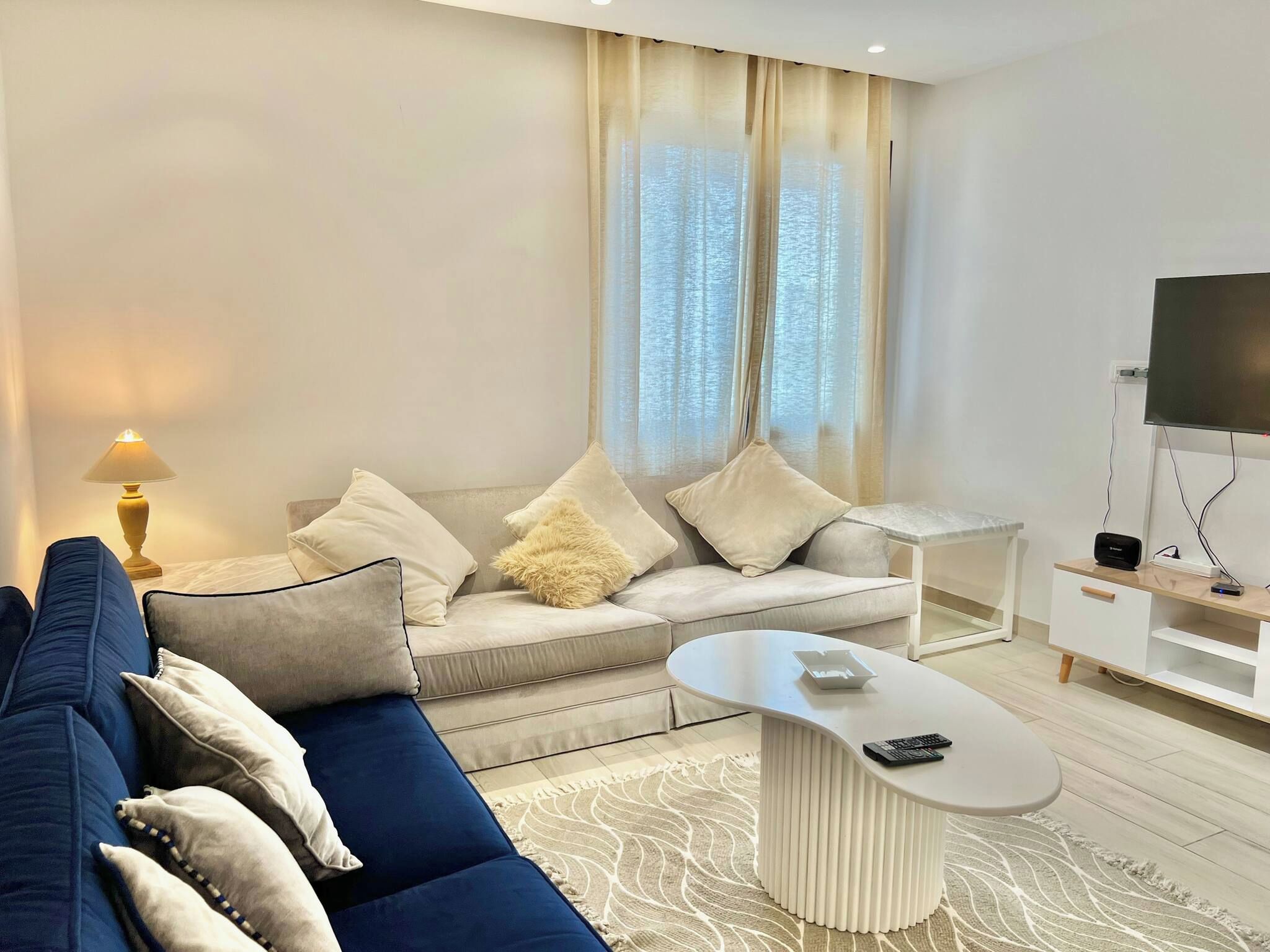 A modern living room with a sofa, coffee table, and TV stand.