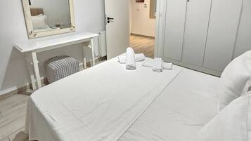 Un dormitorio con cama, cómoda, espejo y armario.