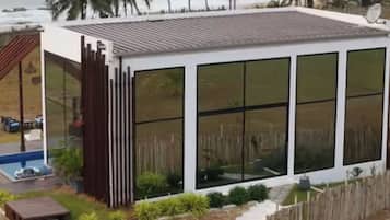 Une maison moderne avec de grandes fenêtres, une piscine et une clôture en bois.