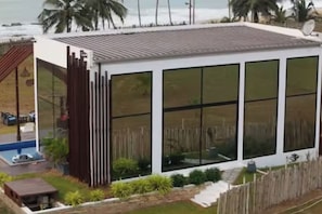 A modern house with large windows, a pool, and a wooden fence.