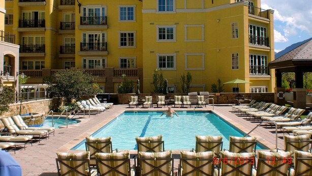 A hotel pool area with multiple lounge chairs and a swimming pool. - Luxury Meets Adventure in Vail – The Ritz-Carlton Club, Vail 2-Bedroom Residence (Vail)
