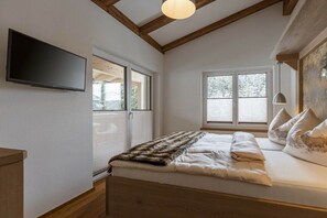 A bedroom with a bed, a television mounted on the wall, and two windows. - Apartment in Mittersill with swimming pool (Mittersill)