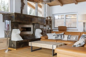 A modern living room with a fireplace, leather sofa, and a coffee table. - Apartment in Mittersill with swimming pool (Mittersill)