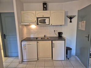 A compact kitchen with a microwave, dishwasher, and a small trash bin. - 1-Bedroom Apartment in JARDINS DU GOLFE with Community Pool (Le Plan-de-la-Tour)