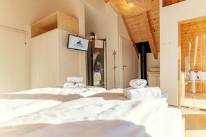 A hotel room with two beds, a wooden ceiling, a TV, and a mirror. - Cabin in Niederwölz with sauna (Niederwölz)