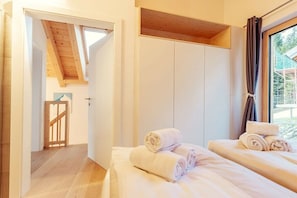 A bedroom with two beds, a wooden ceiling, and a view of the outdoors. - Chalet #2 with 3 bedrooms and sauna (Niederwölz)