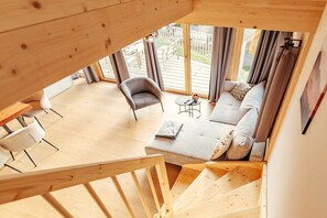 A wooden interior with a sofa, armchairs, and a small table. - Chalet #7 with 3 bedrooms and sauna (Niederwölz)