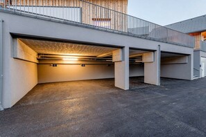 A covered parking area with concrete pillars and a metal railing. - Chalet #7 with 3 bedrooms and sauna (Niederwölz)