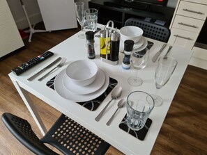 A dining table set with plates, cutlery, glasses, and condiments. - Sav Apartments Rutland Leicester -Studio (Leicester)