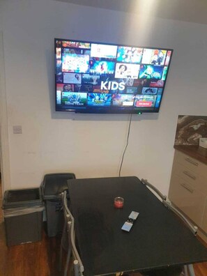 Televisão presa na parede exibindo um canal infantil.