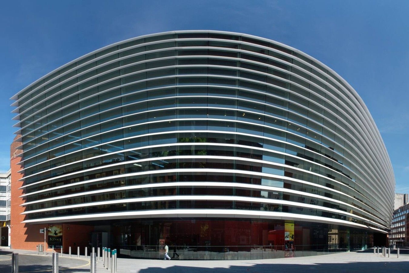A modern curved building with horizontal lines of windows.