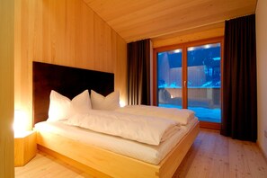 A wooden room with a bed, a window, and curtains. - Chalet with fireplace and balcony (Gaschurn)