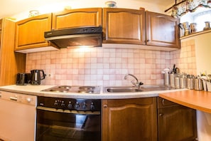 A kitchen with wooden cabinets, a stove, a dishwasher, and a sink. - Holiday home in Neustift with swimming pool (Neustift)