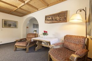 A room with wooden furniture, a table, a lamp, and a painting on the wall. - Holiday home in Neustift with swimming pool (Neustift)