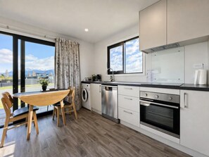 Una cocina moderna con zona de comedor, ventanas amplias y vistas a montañas.
