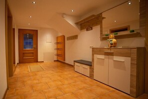 A hallway with a wooden door, a bench, and a counter with a mirror. - Holiday apartment with 2 bedrooms (Neustift im Stuibaital)