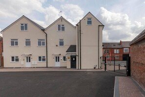 A multi-story residential building with a gated entrance and a driveway. - SAV Clarence Apt, Loughborough - 2-Bed Ladybird (Leicestershire)