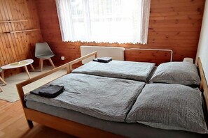 A room with two beds, a small table, and a chair. - Holiday home in Křemže with Wi-Fi and parking (Křemže)