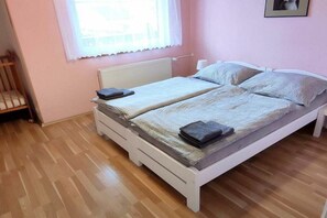 A double bed with a white frame, a bedside table, and a window with a white curtain. - Holiday home in Křemže with Wi-Fi and parking (Křemže)