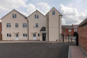A multi-story residential building with a flat roof, a gated entrance, and a driveway. - SAV Clarence Apt, Loughborough - 1-Bed Beacon (Leicestershire)