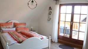 Un dormitorio con cama, mesita de noche, lámpara y ventana con vistas.