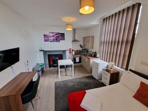 Une chambre d’hôtel compacte comprenant un coin cuisine, un espace repas et un coin salon.