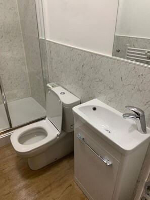 A modern bathroom with a toilet, sink, and shower. - Sav Apartments Regent Leicester - Studio (Leicester)