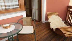 A room with a glass table, wicker chair, and a fur-covered chair. - Large apartment for 2 families (Kleinarl)