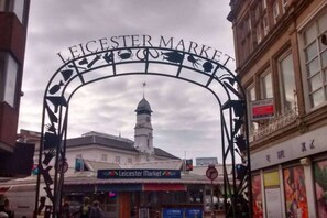 Der Eingang zum Leicester Market, mit einem markanten Bogen und einem Uhrturm im Hintergrund.
