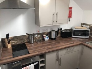Una cocina moderna con estufa integrada, microondas, tostadora y armarios.
