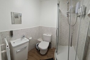A bathroom with a toilet, sink, and shower. - SAV | Regent | Leicester-Studio Close to City Centre (Leicester)