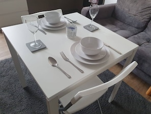 A dining table set with plates, bowls, cutlery, and a glass. - Sav Regent Leicester Twin Studio with Sofa bed (Leicester)