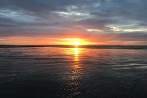 A sunset over a calm body of water with a distant horizon. - Zeebos Holiday Park 24 (Bredene)