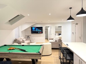 A modern living room with a pool table, a flat-screen TV, and a dining area. - 3 Bed Penthouse Near Airport & Trafford Centre (Wythenshawe)