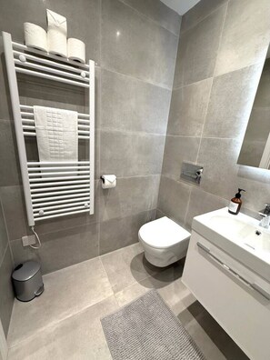 A modern bathroom with a toilet, sink, and towel rack. - Twin+Sofa Bed in Sale Nr Airport & Trafford Centre (Wythenshawe)