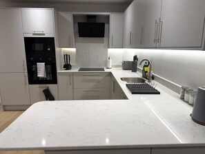 A modern kitchen with a built-in oven, microwave, and a stainless steel sink. - Twin+Sofa Bed in Sale Nr Airport & Trafford Centre (Wythenshawe)