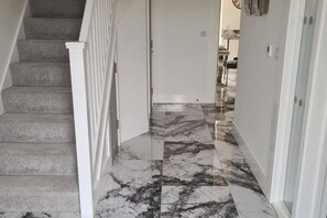 A staircase with carpeted steps leading to a room with a marble floor. - SAV 5-Bed Executive Detached House, Leicester (Scraptoft)