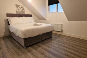 Une chambre à coucher avec un lit, un radiateur et une fenêtre.