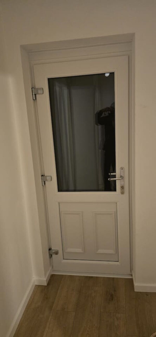 Een witte deur met een ruit en een kleinere deur eronder.