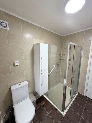 A bathroom with a toilet, a cabinet, and a glass-enclosed shower stall. - 5 Bed Family home near Heathrow l London (Greater London)