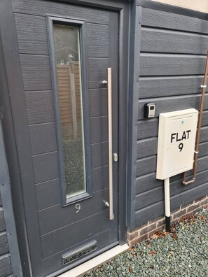 A dark grey door with a window and a doorbell. - SAV Stays 2 Bed Flat, Saffron Leicester-1st Floor (Leicester)
