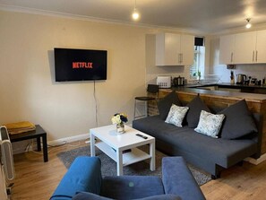 A modern living room with a sofa, coffee table, and a flat-screen TV mounted on the wall. - SAV 1-Bed Flat, Walking Distance to Watford Centre (Hertfordshire)