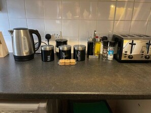 A kitchen counter with a kettle, coffee mugs, sugar, coffee, milk, and a toaster. - SAV 1-Bed Flat, Walking Distance to Watford Centre (Hertfordshire)