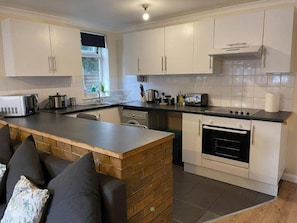A compact kitchen with white cabinets, a built-in oven, and a countertop. - SAV 1-Bed Flat, Walking Distance to Watford Centre (Hertfordshire)
