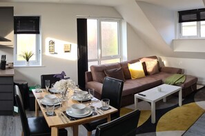 A modern living room with a dining area, a sofa, and a coffee table.