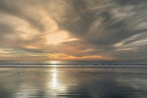 A beach with a calm sea and a sunset. - Holiday apartment with 1 bedroom (Callantsoog)