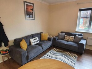 A living room with two grey sofas, a wooden coffee table, and a striped rug. - Sav Apartments Pretoria Watford - 1 Bedroom (Hertfordshire)